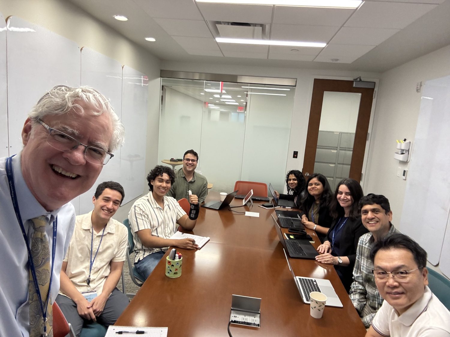 The Deasy Laboratory for Computational Medical Physics and Mathematical Oncology meeting around a conference table. Left to right: Joseph Deasy, PhD (PI); Daniel Grange, PhD (postdoc); Francisco Calderon (undergraduate); Anish Simhal, PhD (postdoc); Himangi Srivastava, PhD (postdoc); Lopamudra Nayak, PhD (postdoc); Leyla Ebrahimpour, PhD (postdoc); Aditya Apte, PhD (faculty); Jung Hun Oh, PhD (faculty).